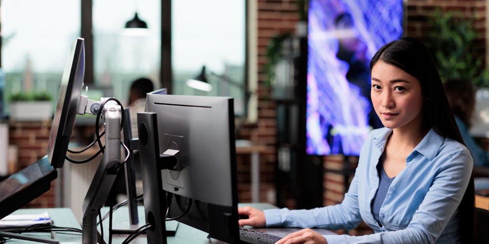 Office user working with a laptop and multiple monitors