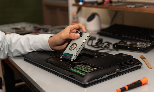 Technician accessing laptop memory and internal storage for maintenance