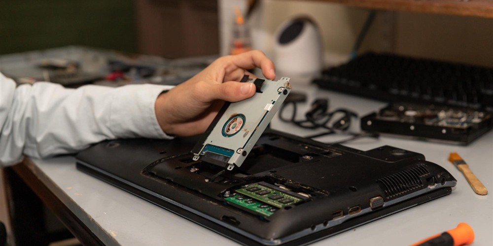 Technician accessing laptop memory and internal storage for maintenance