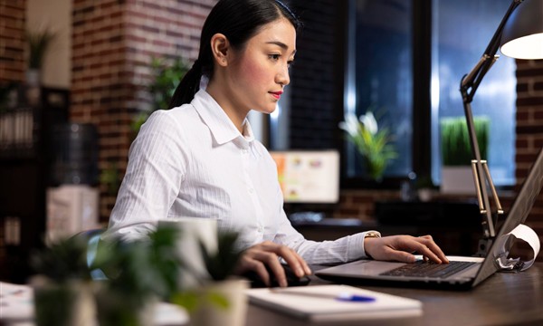 Professional using a laptop for work and study selection in Malaysia