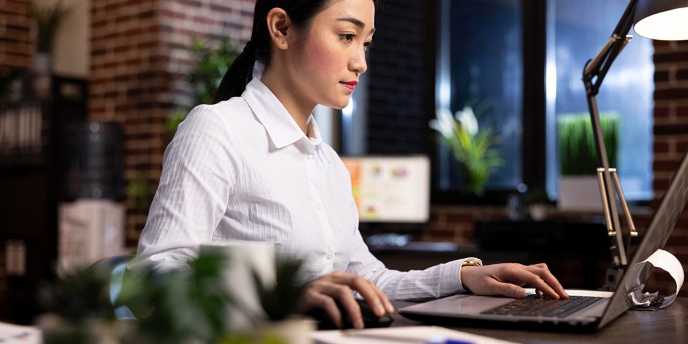 Professional using a laptop for work and study selection in Malaysia
