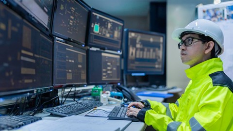 Engineer reviewing AOI inspection data on production monitoring screens